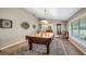 Spacious billiards room with a pool table, statement lighting, and large windows providing natural light at 12104 Elbert St, Clermont, FL 34711