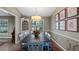 Formal dining room featuring wainscoting, an elegant light fixture, and a large window for natural light at 12104 Elbert St, Clermont, FL 34711