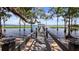 Inviting pathway of the wooden dock stretching out towards the calm, shimmering water at 12104 Elbert St, Clermont, FL 34711