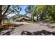 Spacious lakefront property featuring a circular driveway, lush landscaping, and mature trees offering shade and privacy at 12104 Elbert St, Clermont, FL 34711