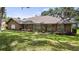 Charming brick home featuring a manicured lawn, mature landscaping, and inviting front entrance with beautiful shutters at 12104 Elbert St, Clermont, FL 34711