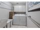 Functional laundry room with washer, dryer, storage cabinets, and ample space for laundry tasks at 12104 Elbert St, Clermont, FL 34711