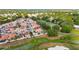 Aerial view of homes on the golf course with mature trees and water views in a lush setting at 1305 Santa Maria Ave, The Villages, FL 32159
