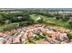 Scenic aerial view of a home on a golf course surrounded by lush greenery and a lake at 1305 Santa Maria Ave, The Villages, FL 32159