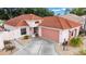 Charming single-story home featuring a red tile roof, two-car garage, and meticulously landscaped front yard at 1305 Santa Maria Ave, The Villages, FL 32159