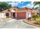 Charming single-story home featuring a red tile roof, two-car garage, and meticulously landscaped front yard at 1305 Santa Maria Ave, The Villages, FL 32159