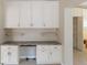 Bright kitchen with white cabinets, tile floor, and view of the adjacent hallway at 1305 Santa Maria Ave, The Villages, FL 32159