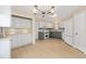 Bright kitchen with white and gray cabinets, stainless appliances and pendant lighting at 1305 Santa Maria Ave, The Villages, FL 32159