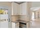 Bright kitchen featuring white cabinets, tile floor, and view of the adjacent exterior door at 1305 Santa Maria Ave, The Villages, FL 32159