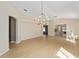 Spacious living room with wood floors, chandelier, and views into other living spaces at 1305 Santa Maria Ave, The Villages, FL 32159
