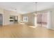 Open-concept living space featuring wood floors, modern chandelier, and sliding glass doors to the patio at 1305 Santa Maria Ave, The Villages, FL 32159