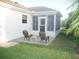 Back patio boasts seating area adjacent to screened in porch perfect for outdoor relaxation at 1310 Jimenez Ct, The Villages, FL 32159