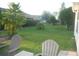 Expansive backyard featuring lush green grass, mature trees and two inviting lounge chairs at 1310 Jimenez Ct, The Villages, FL 32159