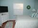Bright bedroom with white bedroom furniture, a queen bed and light blue paint at 1310 Jimenez Ct, The Villages, FL 32159