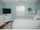 Bright bedroom with white bedroom furniture, a queen bed and light blue paint at 1310 Jimenez Ct, The Villages, FL 32159