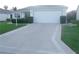 Home with two-car garage, driveway, trimmed hedges, and well manicured green grass at 1310 Jimenez Ct, The Villages, FL 32159