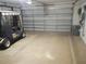 Spacious garage with a golf cart, open garage door, and room for multiple vehicles at 1310 Jimenez Ct, The Villages, FL 32159