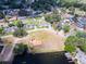 High angle aerial of a lakeside neighborhood with houses, green spaces, mature trees, and community features at 1350 Mosswood Dr, Leesburg, FL 34748