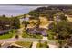 Aerial view of a landscaped home with lush trees, and an adjacent community park with lake access at 1350 Mosswood Dr, Leesburg, FL 34748