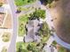 Bird's eye view of a well-maintained property with mature landscaping and a paved driveway on a tree-lined street at 1350 Mosswood Dr, Leesburg, FL 34748