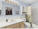 Bathroom with white cabinets and shower-tub combo, view into walk-in closet at 1350 Mosswood Dr, Leesburg, FL 34748