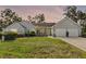 Charming single-story home featuring a well-manicured lawn, mature trees, and an attached two-car garage at 1350 Mosswood Dr, Leesburg, FL 34748