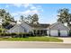 Attractive one-story home with mature landscaping, a two-car garage, and a cozy front porch at 1350 Mosswood Dr, Leesburg, FL 34748