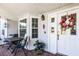 Inviting front porch with seating area, decorative wreath on the front door, and views of the surrounding greenery at 1350 Mosswood Dr, Leesburg, FL 34748