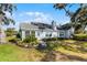 Landscaped front yard with a variety of flowers, shrubs, and trees, creating a welcoming entrance to the home at 1350 Mosswood Dr, Leesburg, FL 34748