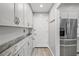 Bright kitchen pantry with stainless steel refrigerator, ample counter space, and modern cabinetry for stylish storage at 1350 Mosswood Dr, Leesburg, FL 34748