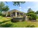 Backyard featuring a seating area, lush lawn, and screened in back porch at 1446 Arbor Trl, The Villages, FL 32162