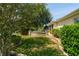 Well-manicured backyard featuring lush lawn, mature trees and landscaping at 1446 Arbor Trl, The Villages, FL 32162