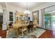 Dining room with wood floors, chandelier, and sliding door access to outdoor patio at 1446 Arbor Trl, The Villages, FL 32162