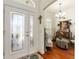 Elegant foyer features a decorative glass door, chandelier, and hardwood flooring at 1446 Arbor Trl, The Villages, FL 32162