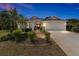 Beautiful home with a manicured lawn, mature landscaping, and an attached two car garage at 1446 Arbor Trl, The Villages, FL 32162