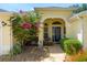 Inviting front porch with seating area and blooming bougainvillea, creating a welcoming entrance at 1446 Arbor Trl, The Villages, FL 32162