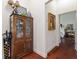 Hallway with hardwood floors leading to a bedroom with comfortable chair and writing desk at 1446 Arbor Trl, The Villages, FL 32162
