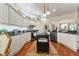 Kitchen with black island, granite countertops, stainless steel appliances, and wood flooring at 1446 Arbor Trl, The Villages, FL 32162