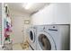Bright laundry room with white cabinets and modern washer and dryer units at 1446 Arbor Trl, The Villages, FL 32162