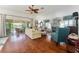 Bright living room features hardwood floors, large windows, and access to a screened patio at 1446 Arbor Trl, The Villages, FL 32162
