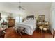 Main bedroom suite featuring wood floors, shuttered windows, and decorative furnishings at 1446 Arbor Trl, The Villages, FL 32162