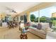 Sunny sunroom with backyard access, comfortable seating, and beautiful garden views at 1446 Arbor Trl, The Villages, FL 32162