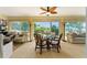 Bright sunroom with a glass-topped dining table, chairs, and backyard views at 1446 Arbor Trl, The Villages, FL 32162