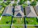 An aerial view of a home with solar panels, lush landscaping, and green grass in a lovely neighborhood at 15322 Veramonte Way, Orlando, FL 32828