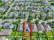An aerial view of a suburban neighborhood highlighting a single-Gathering home, featuring a manicured lawn and solar panels at 15322 Veramonte Way, Orlando, FL 32828