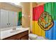This cozy bathroom features a single vanity, a toilet, and a shower with a unique Hogwarts themed shower curtain at 15322 Veramonte Way, Orlando, FL 32828