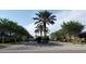 A street view featuring lush landscaping, palm trees, and attractive entryway to a well-maintained neighborhood at 15322 Veramonte Way, Orlando, FL 32828