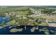 Scenic aerial view of a lakeside community with private docks and lush greenery, offering a tranquil residential experience at 16211 Oak Breeze Ct, Clermont, FL 34711