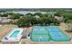 Aerial view of community amenities including a pool and tennis courts in a serene, wooded area at 16211 Oak Breeze Ct, Clermont, FL 34711