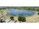 Aerial view of a lake near beautiful homes and tree lined street at 16211 Oak Breeze Ct, Clermont, FL 34711